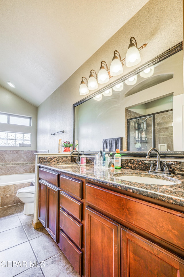 full bathroom with vanity, separate shower and tub, vaulted ceiling, tile patterned flooring, and toilet