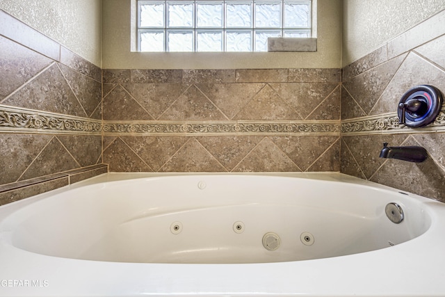 bathroom featuring a bathing tub and a wealth of natural light