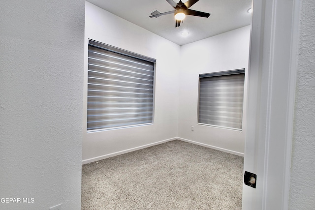 carpeted spare room featuring ceiling fan