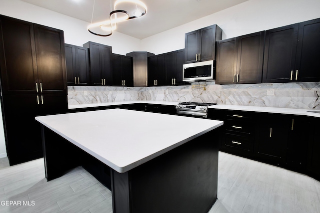 kitchen featuring pendant lighting, a center island, stainless steel appliances, and tasteful backsplash