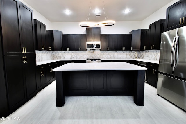 kitchen with backsplash, stainless steel appliances, and a kitchen island