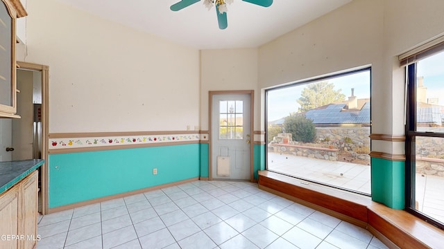 unfurnished sunroom with ceiling fan