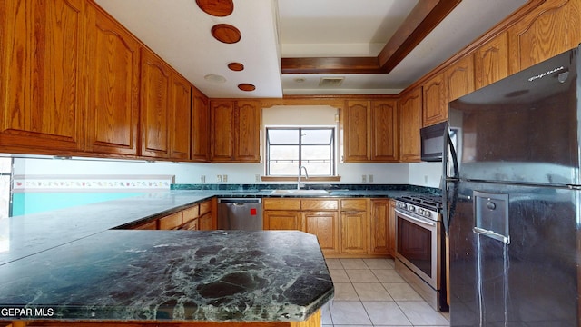 kitchen featuring a tray ceiling, sink, light tile patterned flooring, and black appliances