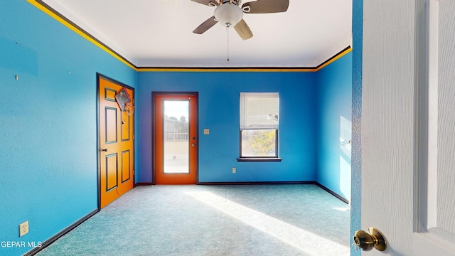 carpeted empty room featuring ceiling fan and ornamental molding