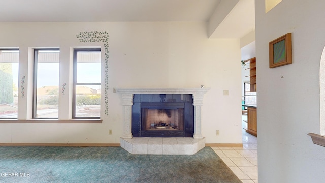 unfurnished living room with a fireplace, a healthy amount of sunlight, and light carpet