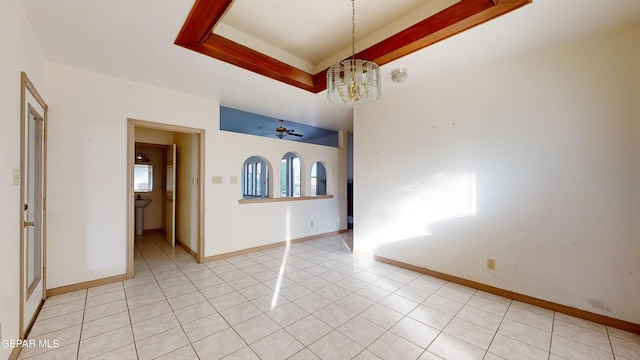 unfurnished room featuring light tile patterned floors and ceiling fan with notable chandelier