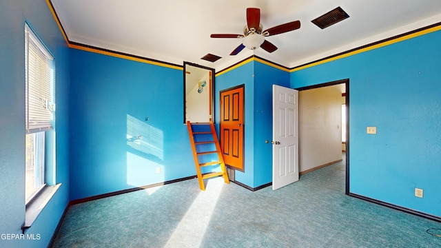 unfurnished bedroom featuring carpet flooring, ceiling fan, and crown molding