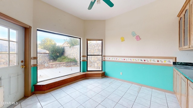 unfurnished sunroom featuring ceiling fan