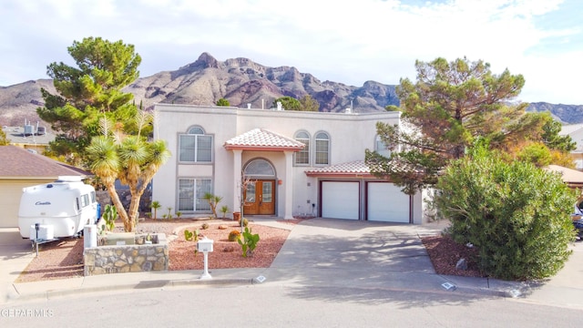 mediterranean / spanish-style house featuring a mountain view, french doors, and a garage