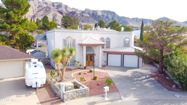 mediterranean / spanish house featuring a mountain view, french doors, and a garage