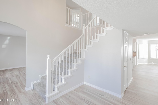 stairway featuring hardwood / wood-style floors and a textured ceiling