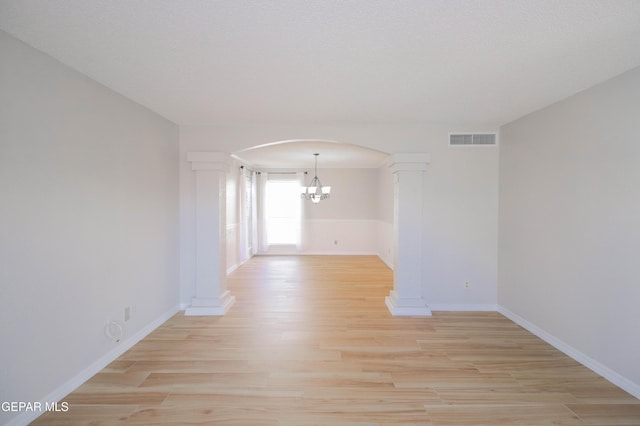 unfurnished room featuring light hardwood / wood-style floors and a notable chandelier