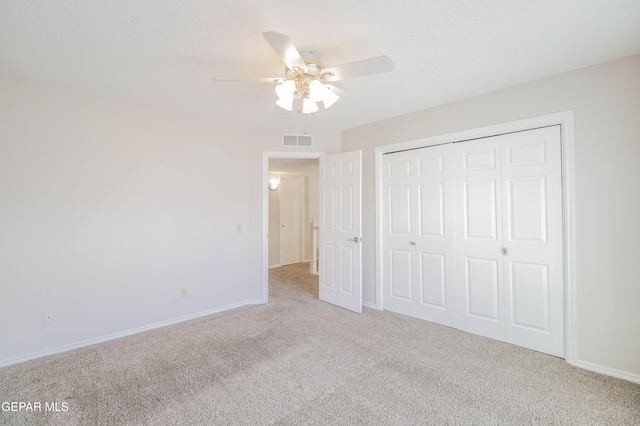 unfurnished bedroom with light carpet, a closet, and ceiling fan