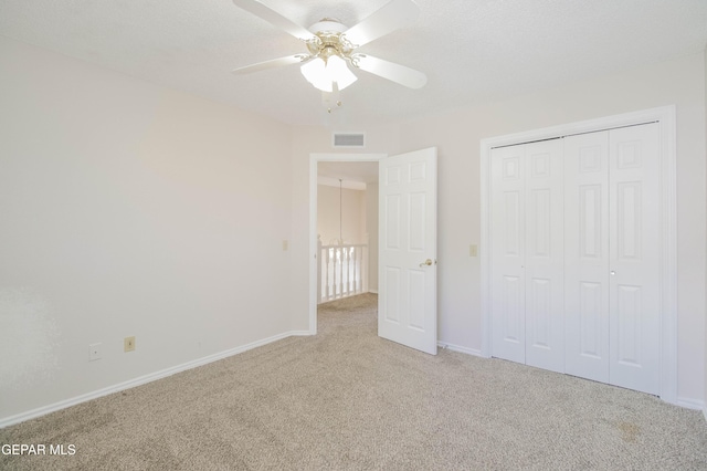 unfurnished bedroom with ceiling fan, a closet, and light colored carpet