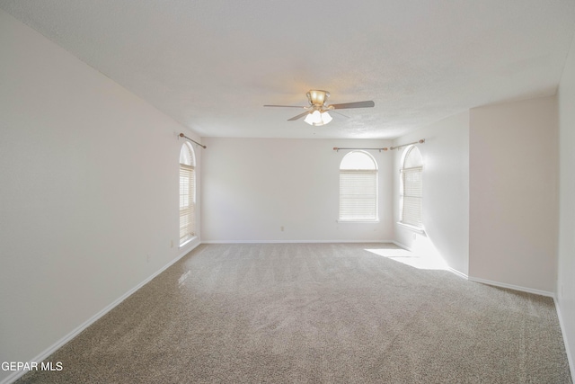 spare room with ceiling fan and light carpet