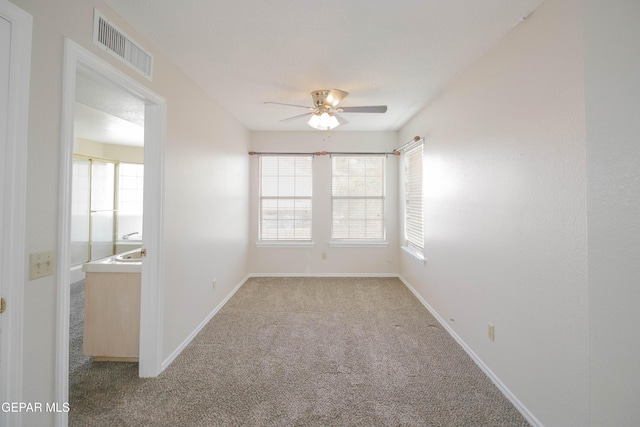 carpeted empty room with ceiling fan and a healthy amount of sunlight