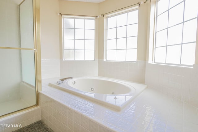 bathroom featuring shower with separate bathtub