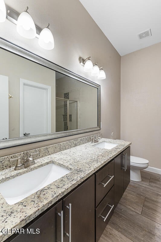 bathroom featuring vanity, toilet, and an enclosed shower