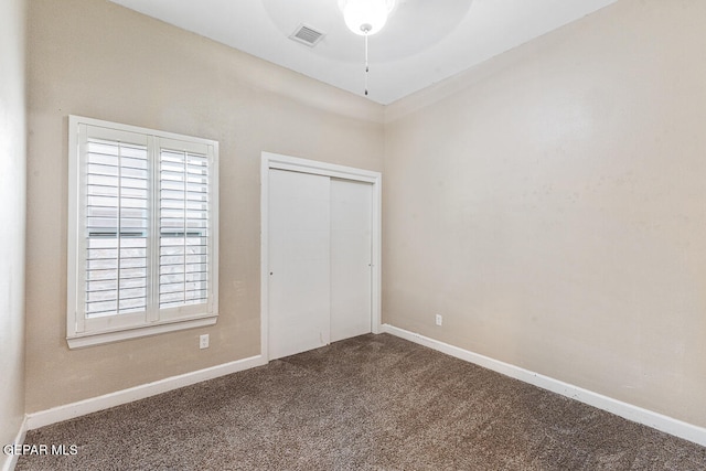 unfurnished bedroom featuring carpet flooring, a closet, and ceiling fan