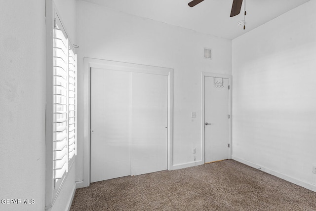 unfurnished bedroom with ceiling fan, carpet floors, and a closet