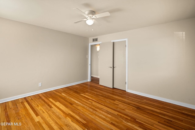 empty room with hardwood / wood-style floors and ceiling fan