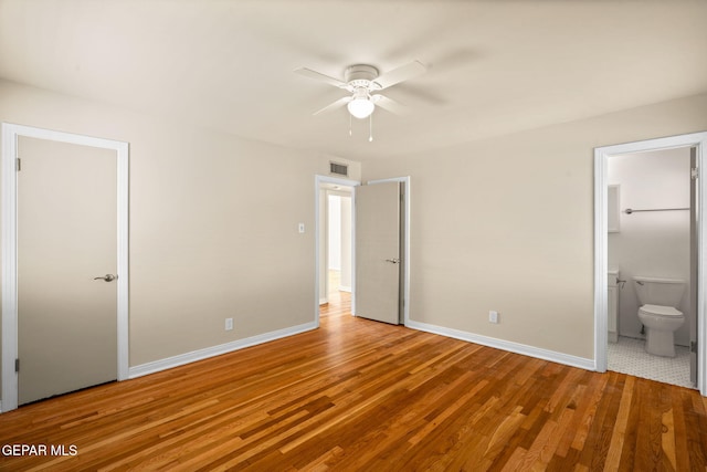 unfurnished bedroom featuring ensuite bathroom, ceiling fan, and hardwood / wood-style flooring