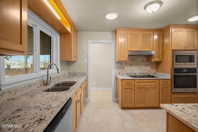 kitchen featuring backsplash, sink, light tile patterned floors, appliances with stainless steel finishes, and light stone counters