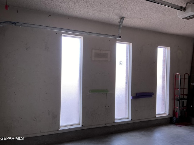 entryway featuring a textured ceiling, concrete floors, and plenty of natural light