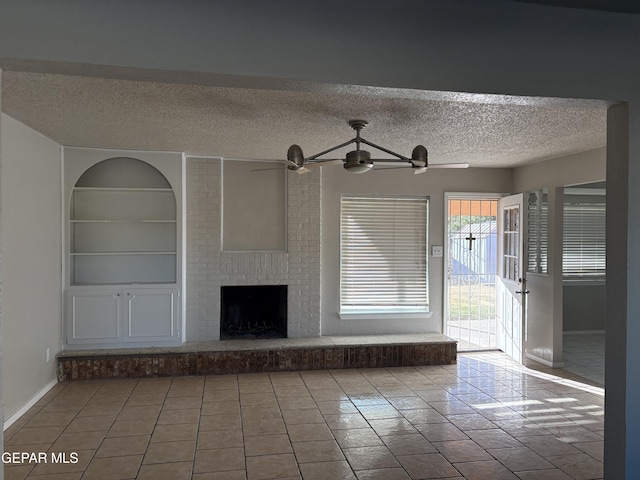 2149 Octubre Dr, El Paso, TX 79935 - unfurnished living room featuring tile patterned flooring, built in features, a fireplace, a textured ceiling, and a ceiling fan