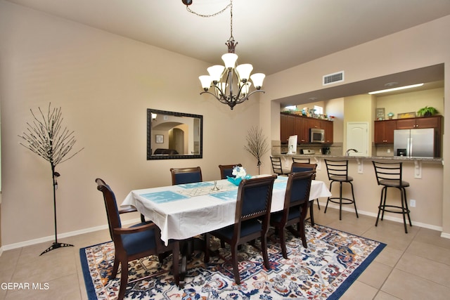 tiled dining space with sink and a notable chandelier