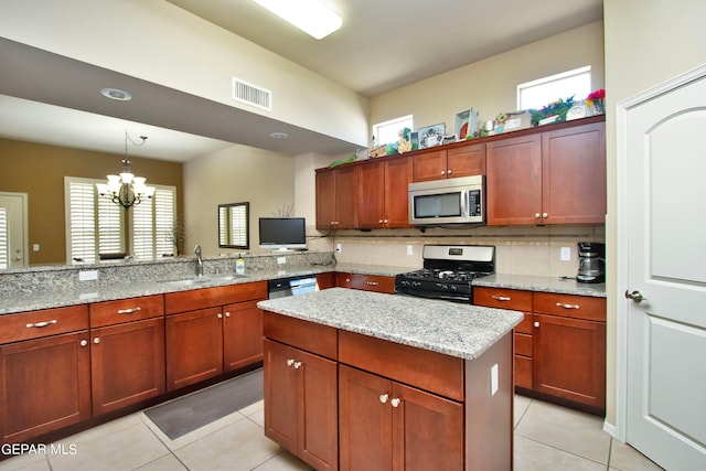 kitchen with sink, hanging light fixtures, stainless steel appliances, an inviting chandelier, and light stone counters