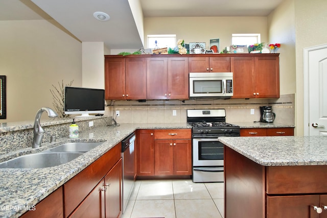 kitchen with light stone counters, sink, plenty of natural light, and stainless steel appliances