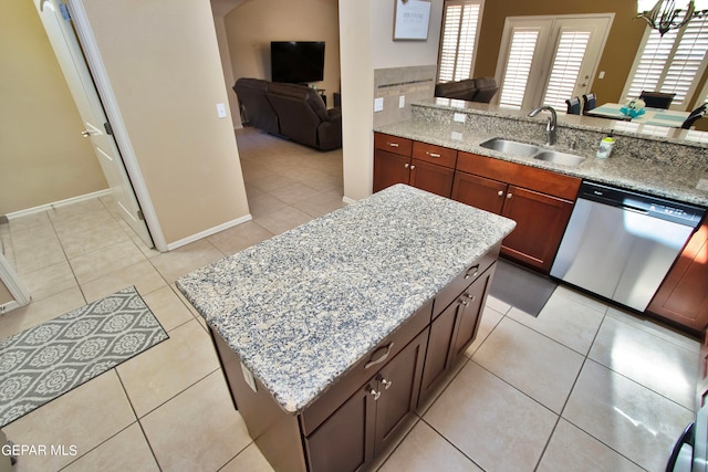 kitchen featuring dishwasher, light stone counters, light tile patterned floors, and sink