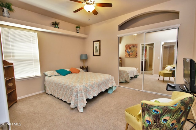 carpeted bedroom featuring ceiling fan and a closet