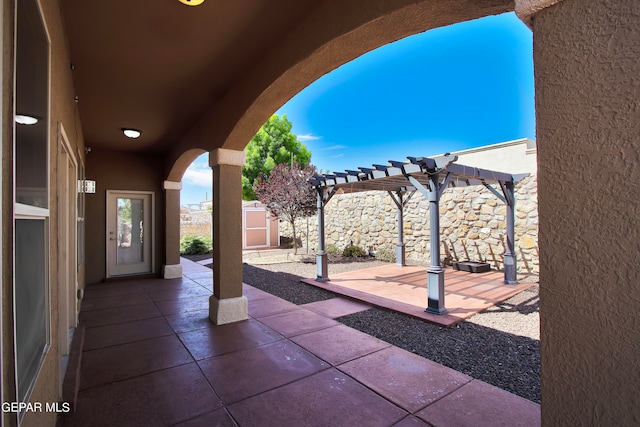 view of patio with a pergola and a storage unit