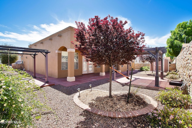 rear view of house featuring a pergola and a patio area