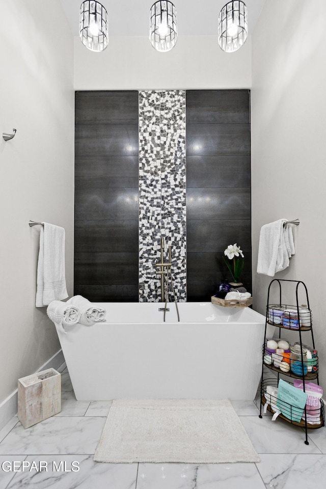 bathroom featuring a notable chandelier and a bathtub