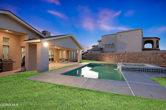 pool at dusk with a lawn, a patio area, central air condition unit, area for grilling, and an in ground hot tub