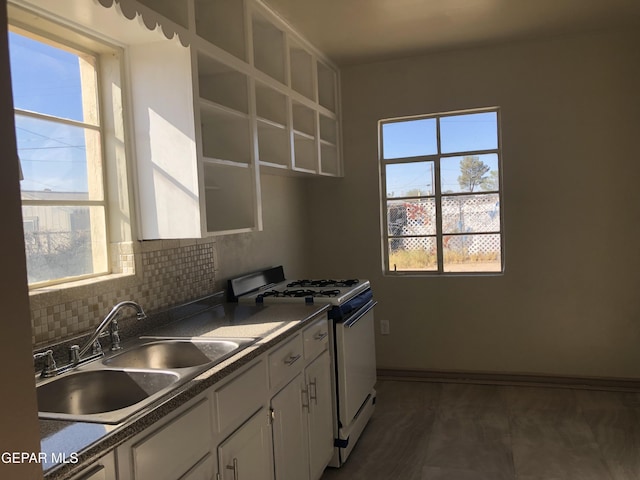 kitchen with white gas range oven, plenty of natural light, and sink