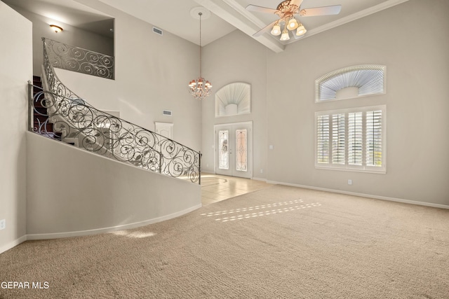 entryway with a high ceiling, french doors, carpet flooring, and ceiling fan with notable chandelier