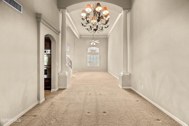 interior space with carpet, a chandelier, ornate columns, and crown molding