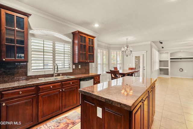 kitchen featuring light tile patterned floors, a chandelier, a center island, ornamental molding, and sink