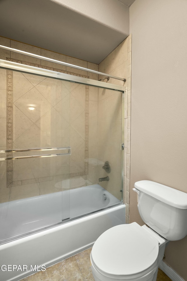 bathroom featuring bath / shower combo with glass door and toilet