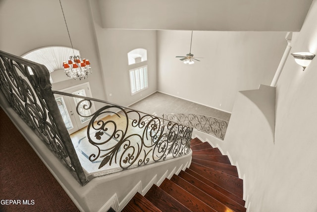 stairs with carpet floors and a notable chandelier