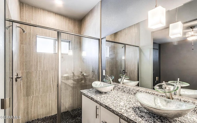 bathroom featuring vanity and a shower with door