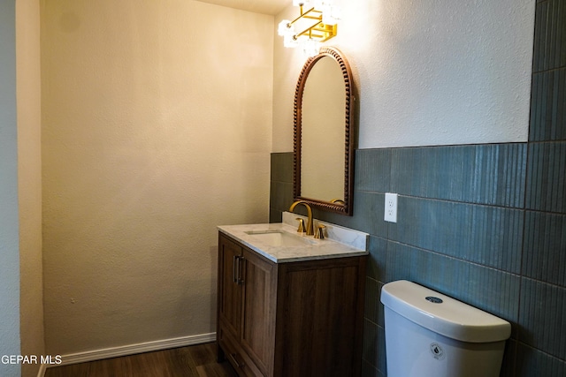 2406 Lebanon Rear, Rear, El Paso, TX 79930 - bathroom with vanity, wood finished floors, toilet, tile walls, and a wainscoted wall