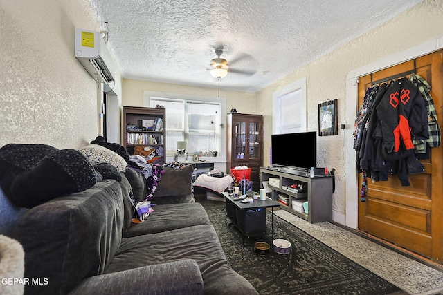 carpeted living room with a wall mounted air conditioner, a textured ceiling, and ceiling fan