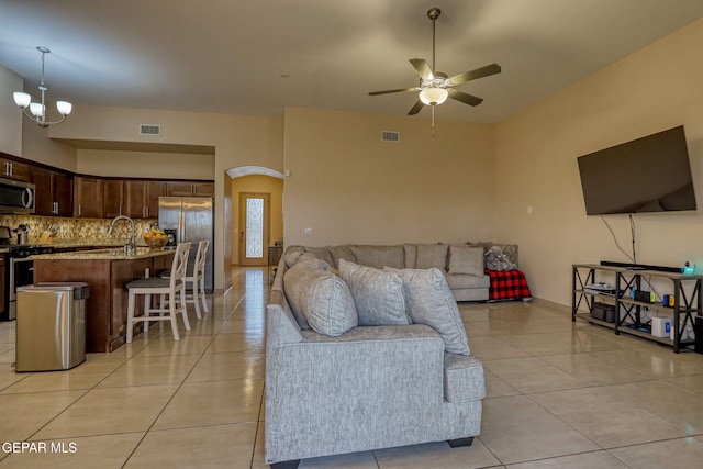 living room featuring ceiling fan with notable chandelier and light tile patterned flooring