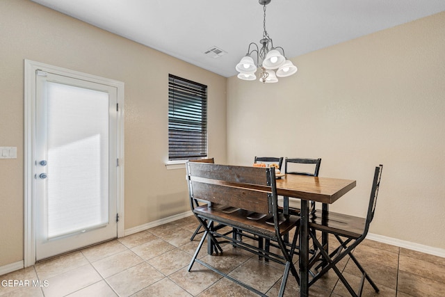 tiled dining area featuring an inviting chandelier