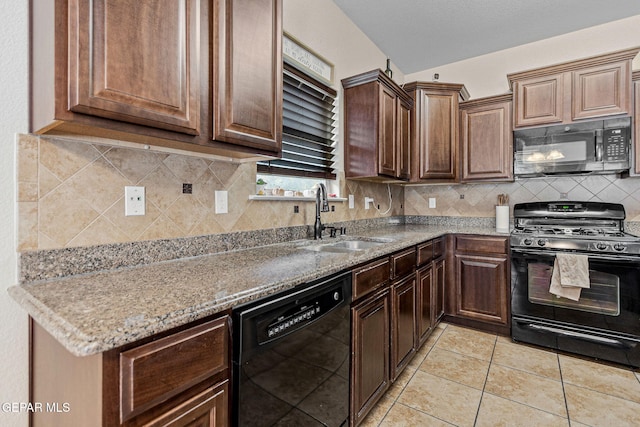 kitchen with sink, light stone counters, decorative backsplash, light tile patterned floors, and black appliances